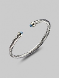 From the Color Classics Collection. A graceful sterling silver cable, capped with faceted blue topaz domes and accents of 14k gold. Blue topaz Sterling silver and 14k yellow gold Cable, 5mm Diameter, about 2¼ Imported