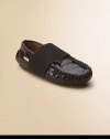 A classic moccasin design in embossed crocodile patent leather keeps the foot in place with a thick elastic strap.Slip-on with elastic closureLeather upperLeather liningRubber solePadded insoleImported