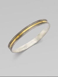 From the Lancelot Collection. Thoroughly modern and thoroughly stunning, this slender bangle of hammered sterling silver with ridged and fluted edges is encircled by a gleaming band of 24k gold.Sterling silver and 24k yellow goldDiameter, about 2½Imported