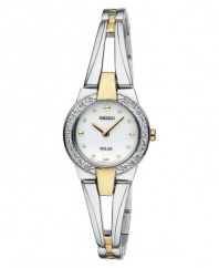 Add a new favorite to your jewelry box with this elegant and energy-efficient watch by Seiko. Polished two-tone stainless steel bangle bracelet and round case, 22mm. Bezel crystallized with Swarovski elements. White dial features gold tone dot markers, two hands and logo. Solar-powered quartz movement. Water resistant to 30 meters. Three-year limited warranty.