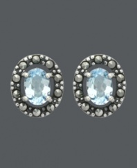 Button up your look in light blue hues. Genevieve & Grace stud earrings feature beautiful, oval-cut blue topaz gemstones (1-1/2 ct. t.w.) encircled by glittering marcasite. Crafted in sterling silver. Approximate diameter: 1/2 inch.